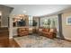 Spacious living room with hardwood floors, leather sofas, and view into dining room at 7076 S Niagara Ct, Centennial, CO 80112