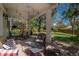 Relaxing covered patio featuring cushioned seating and views of the landscaped backyard at 7076 S Niagara Ct, Centennial, CO 80112
