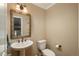 Charming powder room with pedestal sink, decorative mirror, and neutral color scheme at 7076 S Niagara Ct, Centennial, CO 80112