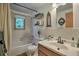 Bathroom features a tub and shower combo, decorative mirror and accents, and a tiled sink vanity at 609 Brook Dr, Idaho Springs, CO 80452
