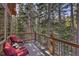 Outdoor deck with forest views, red lounge chairs, and a cocktail table create a relaxing space at 609 Brook Dr, Idaho Springs, CO 80452