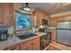 The kitchen has wood cabinets, stainless appliances, a granite counter, and a double sink with a window view at 609 Brook Dr, Idaho Springs, CO 80452
