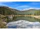 Scenic lake view reflecting the sky, with trees and mountains in the background at 609 Brook Dr, Idaho Springs, CO 80452
