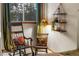 Cozy sitting area features rocking chairs, decorative pillows, rustic lamp and a picturesque window view at 609 Brook Dr, Idaho Springs, CO 80452