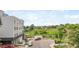 View of the building, parking lot and the surrounding neighborhood with trees and a train station at 1208 Quitman St # 305, Denver, CO 80204
