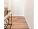 Hallway with wood-like flooring and decorated with elegant console table and a painting at 1208 Quitman St # 305, Denver, CO 80204