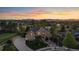 Stunning aerial view of a two-story home with landscaped yard against the backdrop of a colorful sunset and mountain range at 9375 Webster Way, Westminster, CO 80021