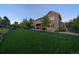 Spacious backyard featuring a covered patio, mature trees, and lush green lawn at 9375 Webster Way, Westminster, CO 80021