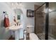 Cozy bathroom with stand up shower, pedestal sink and a decorative shelf with fresh rolled towels at 9375 Webster Way, Westminster, CO 80021