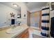 Classic bathroom features a shower-tub combo with a navy striped curtain and earth-tone tile at 9375 Webster Way, Westminster, CO 80021