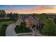 Beautiful home at sunset with landscaped front yard, lush trees, circular driveway, and mountain views at 9375 Webster Way, Westminster, CO 80021