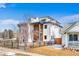 Modern multi-story home with balconies, white siding, and black iron fencing around the front yard at 3522 S Ogden St, Englewood, CO 80113