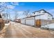 Back view of a home featuring a two car garage with white doors and a long driveway at 3522 S Ogden St, Englewood, CO 80113