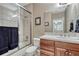 Well-lit bathroom featuring a shower over tub, neutral tile and wood vanity with granite counters at 8707 Windhaven Dr, Parker, CO 80134