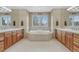 Bathroom showcasing a jetted tub with dual sinks and vanity, and large mirrors at 8707 Windhaven Dr, Parker, CO 80134
