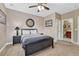 Bedroom with carpet, furniture and a ceiling fan; bathroom is visible through the doorway at 8707 Windhaven Dr, Parker, CO 80134