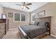 This bedroom offers a ceiling fan and natural light from two windows overlooking the greenery at 8707 Windhaven Dr, Parker, CO 80134