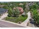 Beautiful home exterior with lush landscaping, mature trees, and a spacious front lawn at 8707 Windhaven Dr, Parker, CO 80134