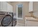 Bright laundry room featuring a large capacity washer and dryer, window, and utility sink at 8707 Windhaven Dr, Parker, CO 80134