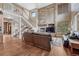 Inviting living room with stone fireplace, hardwood floors, and grand staircase at 8707 Windhaven Dr, Parker, CO 80134