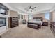 Spacious main bedroom with a fireplace, tray ceilings, ceiling fan, and large windows at 8707 Windhaven Dr, Parker, CO 80134