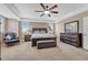 Bright main bedroom with furniture, tray ceilings, carpet flooring, and windows at 8707 Windhaven Dr, Parker, CO 80134