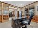 Well-appointed home office with wood trim, a large desk, and comfortable seating at 8707 Windhaven Dr, Parker, CO 80134