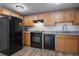 Modern kitchen with light wood cabinets and black appliances at 2850 E College Ave # 2, Boulder, CO 80303