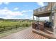 Multi-level backyard deck with outdoor seating overlooking a lush green landscape and clear sky at 3871 Starry Night Loop, Castle Rock, CO 80109