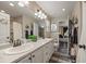 Bright bathroom features double sinks with white cabinets and access to the main bedroom at 3871 Starry Night Loop, Castle Rock, CO 80109