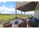 Relax on the outdoor deck with wicker furniture, a table, and views of the green lawn and distant hills at 3871 Starry Night Loop, Castle Rock, CO 80109