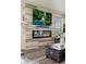 Cozy living room featuring a modern fireplace, flatscreen television, and rustic wood accent wall at 3871 Starry Night Loop, Castle Rock, CO 80109