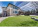 Spacious backyard featuring lush green grass, patio area and mature trees at 10375 Knollside Dr, Parker, CO 80134