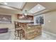 Basement bar area with brick accents, granite countertop, pendant lighting and bar stool seating at 10375 Knollside Dr, Parker, CO 80134