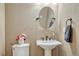 Cozy half bath with pedestal sink, oval mirror and beautiful decorative accents at 10375 Knollside Dr, Parker, CO 80134