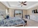 Comfortable carpeted bedroom featuring a trey ceiling, ceiling fan, and a desk with a computer workstation at 10375 Knollside Dr, Parker, CO 80134