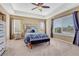 Comfortable carpeted bedroom featuring a trey ceiling, ceiling fan, and two windows with beautiful natural light at 10375 Knollside Dr, Parker, CO 80134