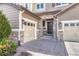 A side view of a home with stone accents and a two-car garage and large entry door with sidelight at 10375 Knollside Dr, Parker, CO 80134
