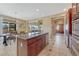 A kitchen island features stainless appliances, a sink, granite counter and dark wood cabinetry and a dining area nearby at 10375 Knollside Dr, Parker, CO 80134