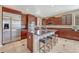 An open-concept kitchen boasts a granite-topped island, stainless appliances, and rich wood cabinets with barstool seating at 10375 Knollside Dr, Parker, CO 80134