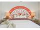 Close up view of the bed in the vibrant bedroom with rainbow wall art at 2153 Flower Blossom Ave, Brighton, CO 80601