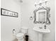 Stylish half bath with ornate mirror, pedestal sink and all white walls at 930 Button Rock Dr # 28, Longmont, CO 80504