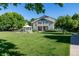 Green townhome featuring a well-kept lawn, white gazebo, and mature trees in a peaceful setting at 930 Button Rock Dr # 28, Longmont, CO 80504