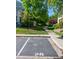 Assigned parking spot near a sidewalk amid green lawn and trees under a clear blue sky at 930 Button Rock Dr # 28, Longmont, CO 80504