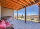 Covered patio features an outdoor kitchen, comfortable seating, and beautiful views at 6450 S Riverwood Ct, Aurora, CO 80016