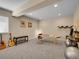 Spacious basement with neutral carpet, guitars, massage table, and workout equipment at 6450 S Riverwood Ct, Aurora, CO 80016