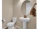 Comfortable powder room featuring a pedestal sink, round mirror, and bronze fixtures at 6450 S Riverwood Ct, Aurora, CO 80016