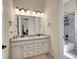 Bathroom featuring a double sink vanity, granite countertop, and updated fixtures at 6450 S Riverwood Ct, Aurora, CO 80016
