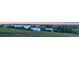 Panoramic view of a serene lake surrounded by green landscape under a colorful sky at 6450 S Riverwood Ct, Aurora, CO 80016