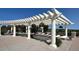 Relaxing poolside scene with comfortable lounge chairs and hanging flower baskets under a pergola at 6450 S Riverwood Ct, Aurora, CO 80016